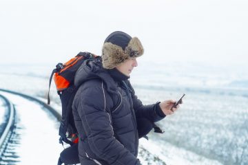 Man i vinterkläder navigerar med sin telefon
